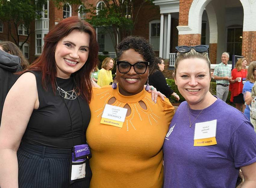 Three Converse alumni stand smiling at a Reunion event.